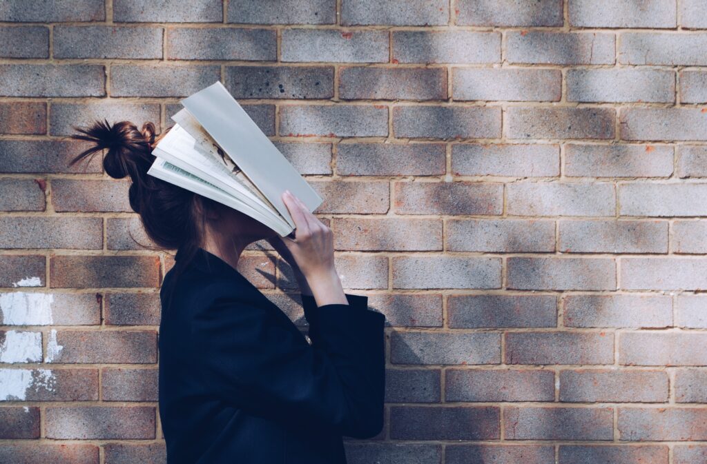 Frau mit Buch über dem Kopf